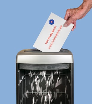 Absentee ballot of vote by mail envelope being shredded in an office shredder photo