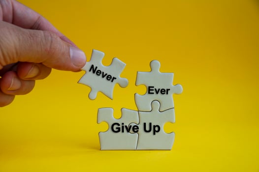 Motivational text on jigsaw puzzle with hand holding a missing jigsaw - Never ever give up. photo