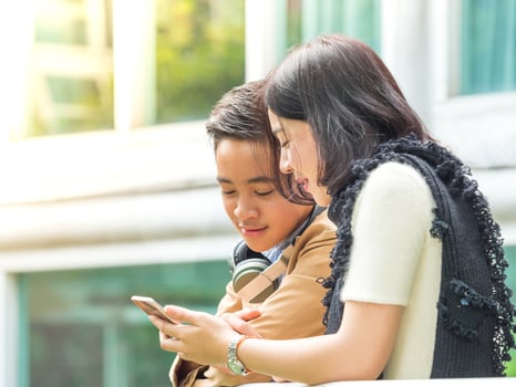 Young boy and girl play games on mobile phones photo