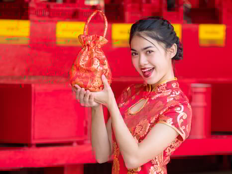 Asian women in Chinese national costumes hold greeting bag for the Chinese New Year event photo