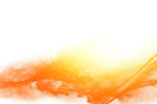Yellow orange dust particles explosion on white background. Powder dust splash. photo