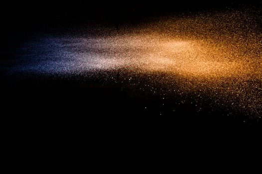 Blue orange dust particles explosion on black background. Color powder dust splash. photo