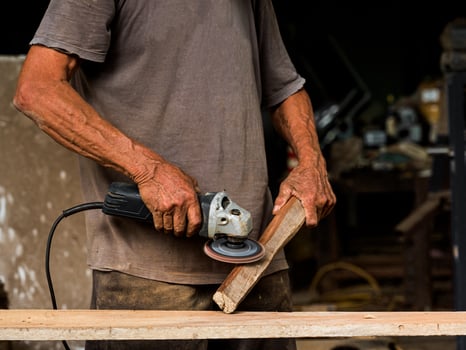 Professional technicians in the factory are using power tools to polish the wooden photo