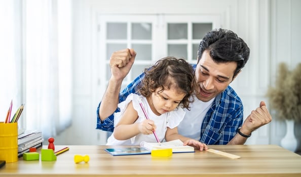 Portrait of young father teaching his cute little daughters' study. Excited smiling small child girl enjoying learning with pleasant dad at home. Children education, home schooling concept photo