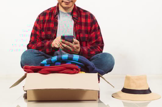 man holding a crate of second-hand clothes unused clothes photo