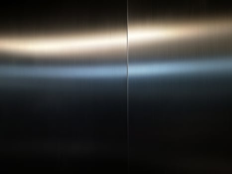 Stainless steel large sheet  With light hitting the surface  For background,Inside passenger elevator,Reflection of light on a shiny metal texture,stainless steel background. photo