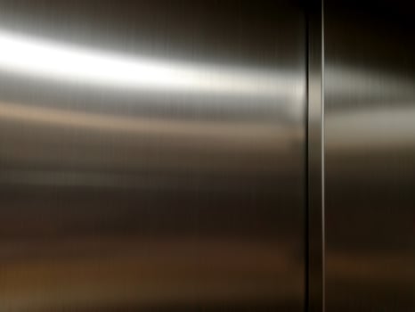 Stainless steel large sheet  With light hitting the surface  For background,Inside passenger elevator,Reflection of light on a shiny metal texture,stainless steel background. photo