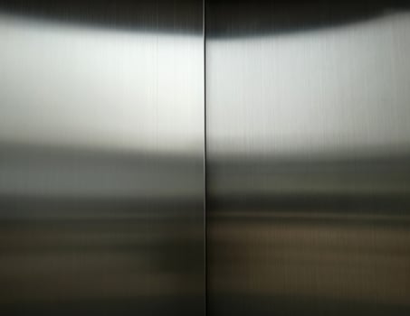 Stainless steel large sheet  With light hitting the surface  For background,Inside passenger elevator,Reflection of light on a shiny metal texture,stainless steel background. photo