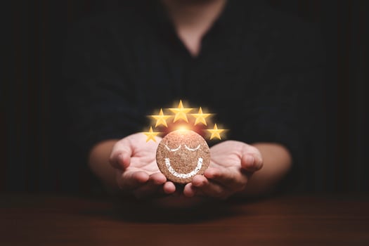 Businessman holding and giving smile face with five golden stars which print screen on round wooden for client or customer excellent evaluation after use product and service concept. photo