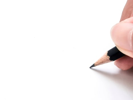 hand holding a black pencil ready to write something on paper photo