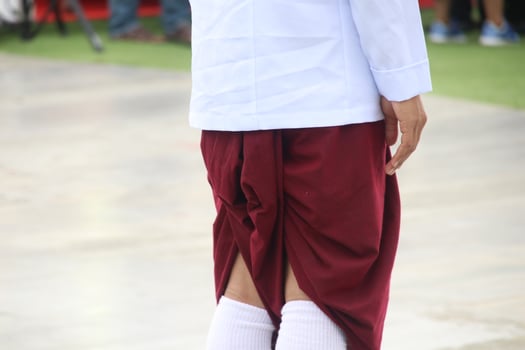 A man wears Thai red loincloth and white shirt, back view. photo