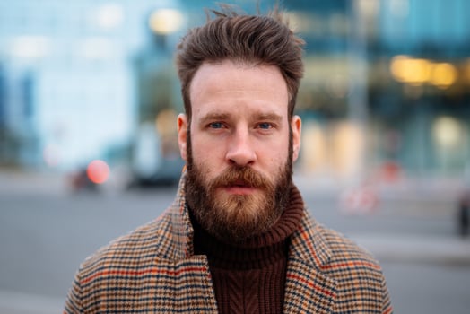 Close up portrait of hipster man in business centre area. Looking to camera photo