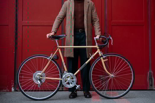 Young businessman with bike over red wall background in a city. Red color background photo