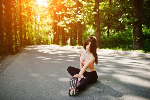 Fitness sport girl in sportswear sitting in road at park, outdoor sports, urban style. photo