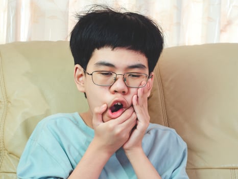 Little asia boy suffer from toothache. He sad with tooth pain, dental disease, kid suffering from dental problem. Plan to appointment dentist. photo