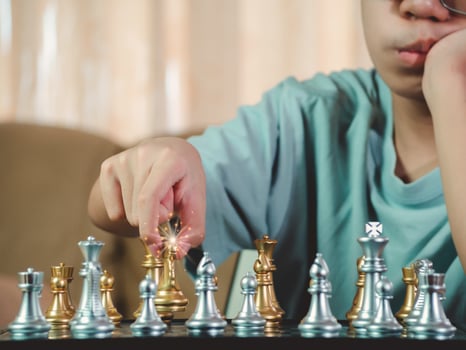 Concentrated serious boy developing chess gambit, strategy ,playing board game to winner clever concentration and thinking child while playing chess. Learning, tactics and analysis concept. photo