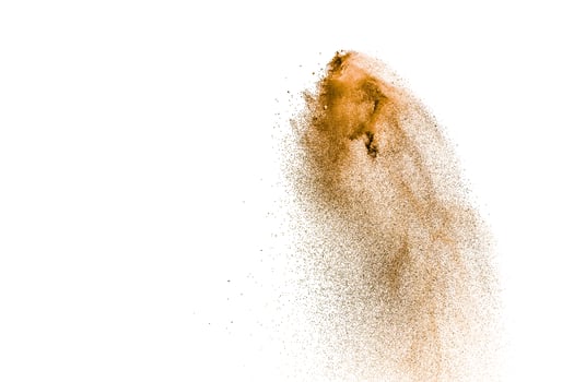 Brown dry river sand explosion isolated on white background. Abstract sand splashing. photo
