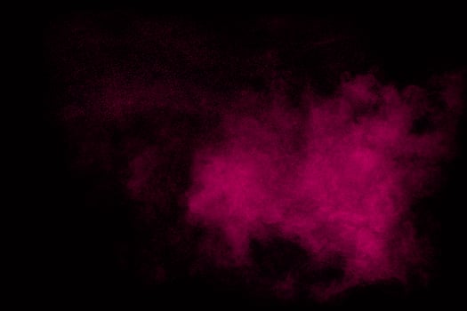 Pink dust particles splash on black background.Pink powder splash. photo