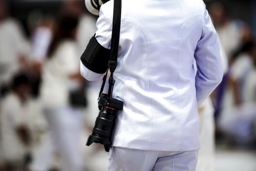 Professional cameraman back hanging strap and mirrorless camera with blur crowd background. photo