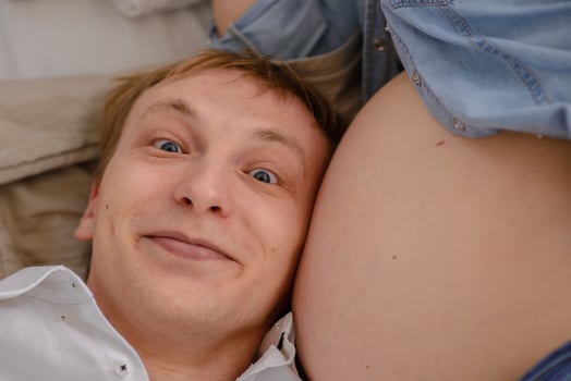 The future father listens as his child beats in the belly of his pregnant wife. photo