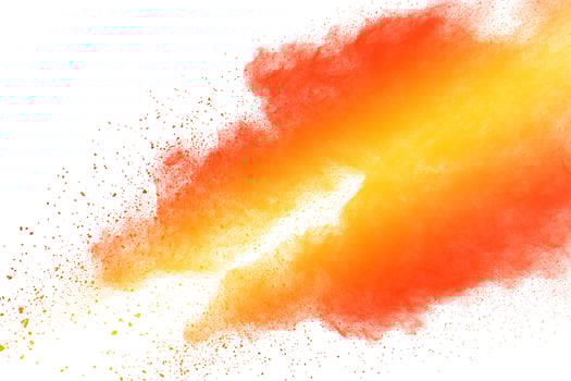 Abstract yellow orange powder explosion on white background. Freeze motion of orange  dust particles splash. photo