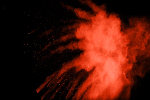 Red color powder explosion on black background. photo