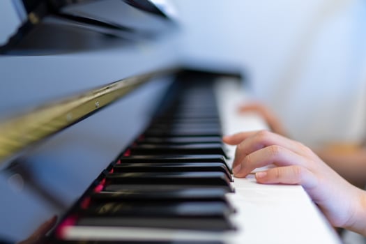 Playing piano with boy hand shalow focus on keyboard and left finger photo