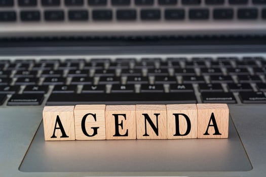 Agenda text on wooden block placed on laptop or notebook. Meeting concept. photo