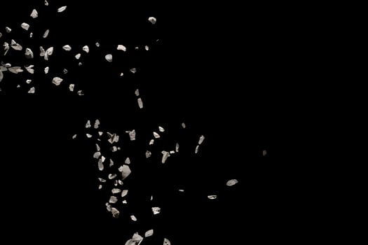 Split debris of stone exploding against black background. photo