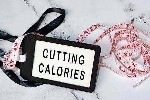 Cutting calories on black name tag with measure tap on white desk. photo