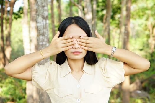 Asian women cover their eyes with both hands nature background photo