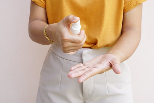 Women's hands using alcohol spray or antibacterial spray to prevent the spread of germs, bacteria and viruses. photo