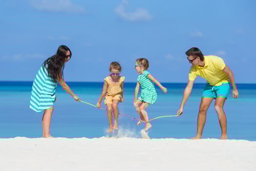 Happy family playing together on white beach photo