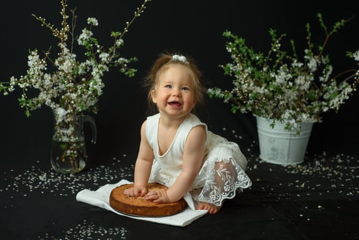 Little girl celebrates her first birthday. Girl eating her first cake. photo