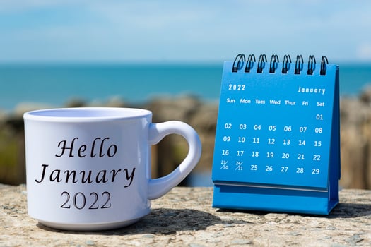 Hello Hello January 2022 written on white coffee cup with blue calendar photo