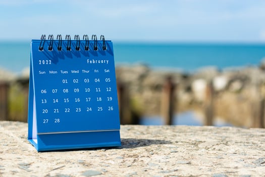 Blue February 2022 calendar on blurred background of blue ocean photo