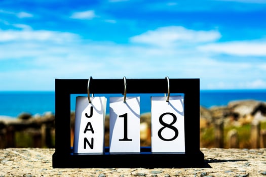 Jan 18 calendar date text on wooden frame with blurred background of ocean photo