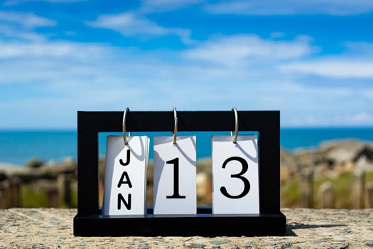 Jan 13 calendar date text on wooden frame with blurred background of ocean photo