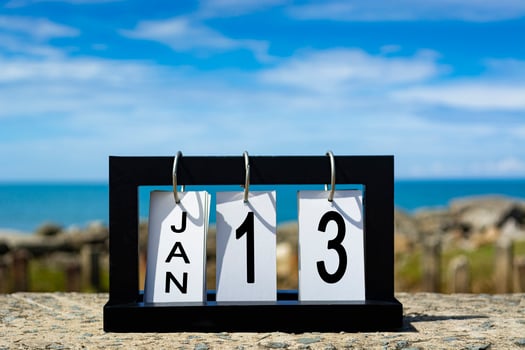 Jan 13 calendar date text on wooden frame with blurred background of ocean photo