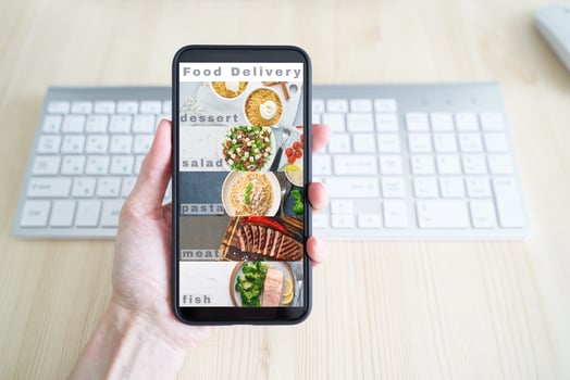Contactless food delivery. App on your phone. Mobile phone screen. Person holds smartphone photo