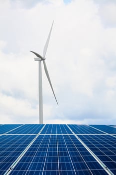 solar panels and wind turbines with the clouds and sky photo