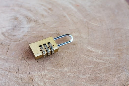 Close up pad lock on wooden background photo