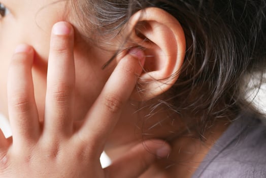 child girl having ear pain touching his painful ear , photo