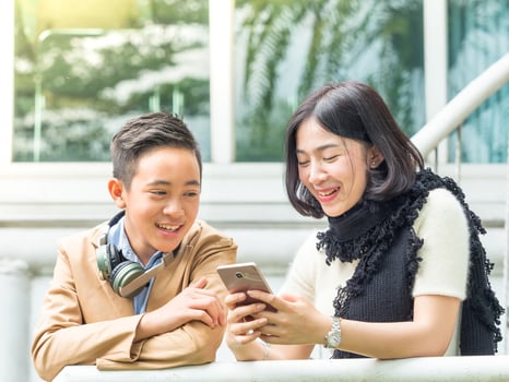 Young boy and girl play games on mobile phones photo