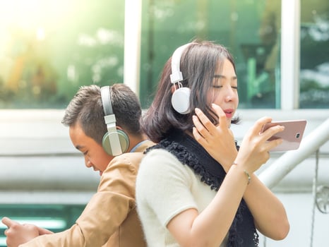 Young boy and girl play games and listen to music on their mobile phones photo