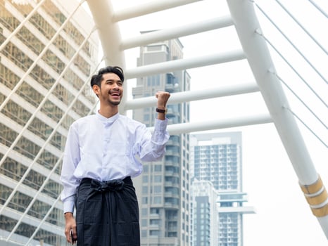 Young Burmese businessman happy after using mobile phone to find a data for his business photo