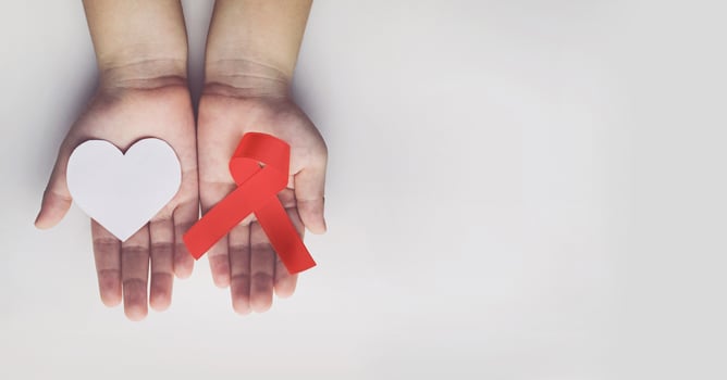 Kid hands holding red AIDS awareness ribbon. Aids Awareness photo