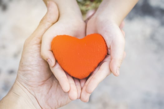 Small kid hands holding heart photo