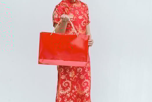 Asian woman holding shopping bag, woman wear cheongsam, chinese new year photo