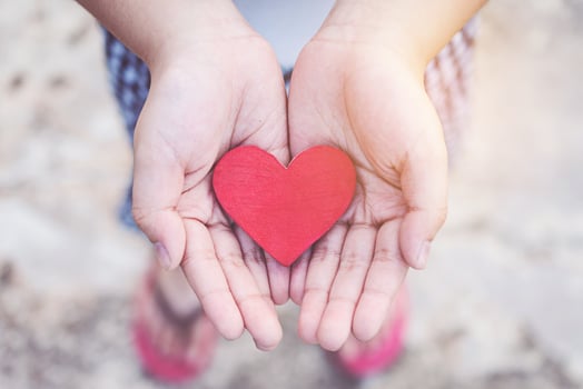 Small kid hands holding heart photo